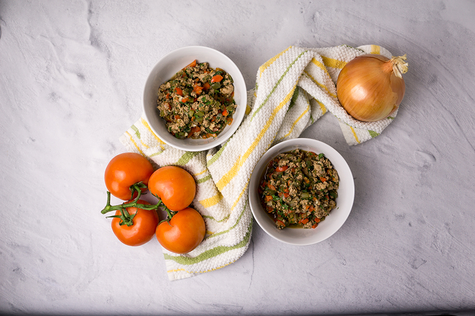 two bowls of turkey chill fry with an onion and tomatoes