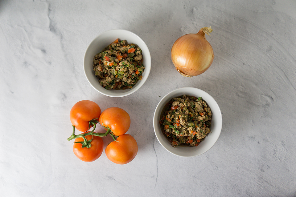 two bowls of turkey chill fry with an onion and tomatoes