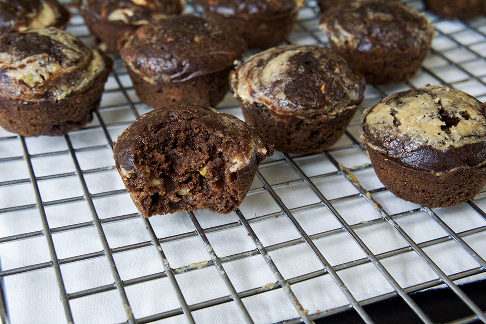 Bite out of a chocolate zucchini tahini swirl Muffin