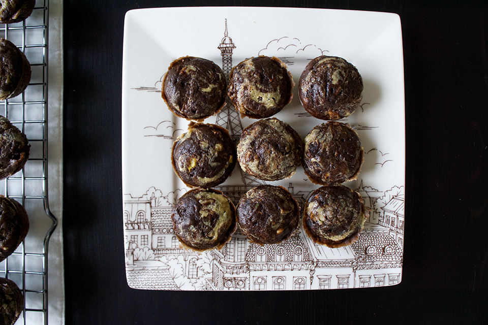 Chocolate zucchini tahini swirl muffins on a white plate